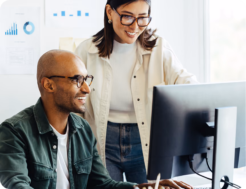 Two coworkers looking at a computer