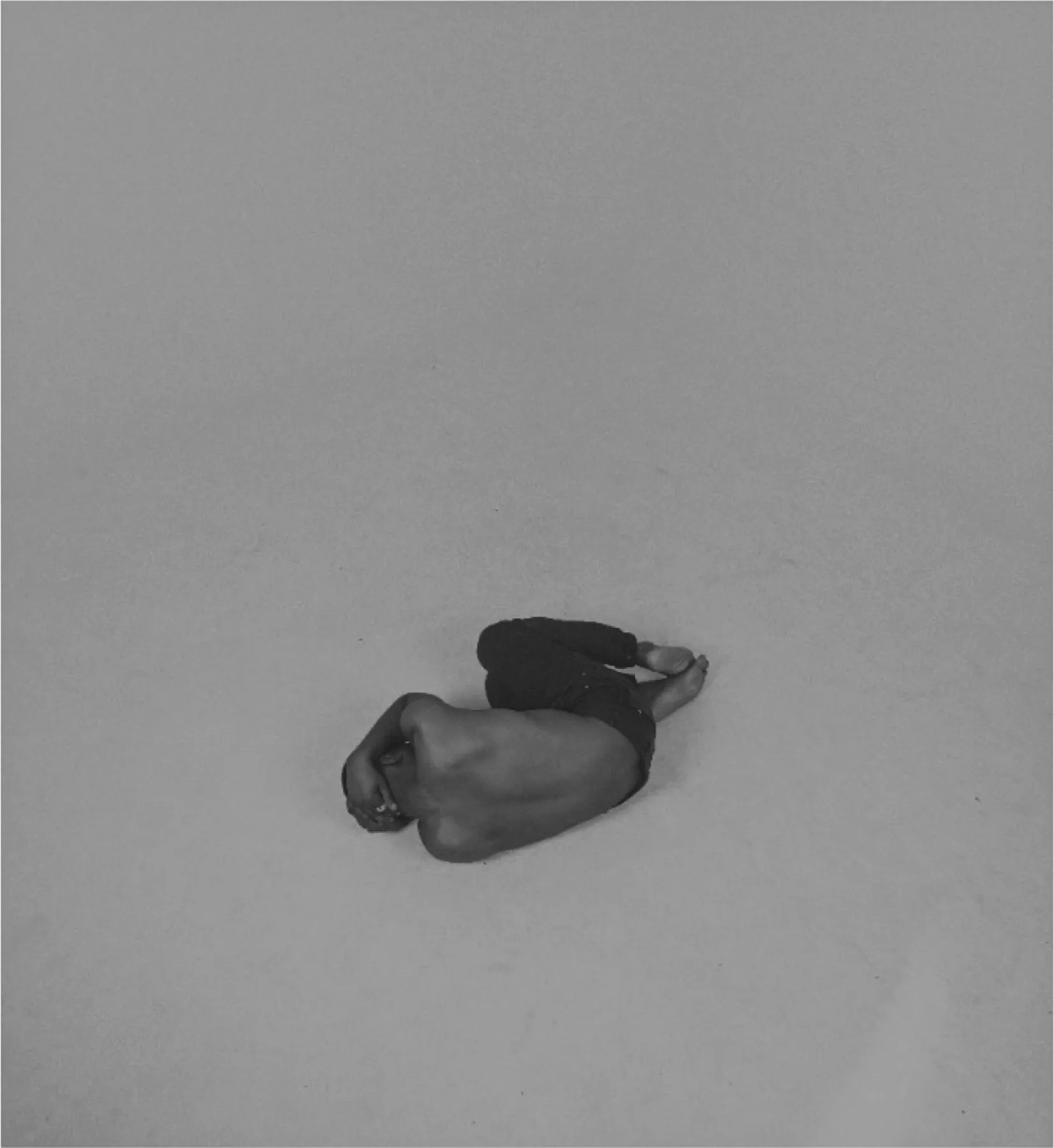 a man curled up on the ground inside a photography studio