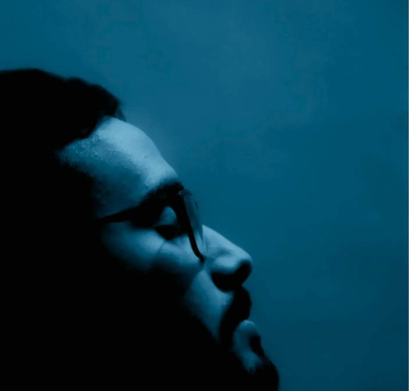 a man looking in the distance blue background