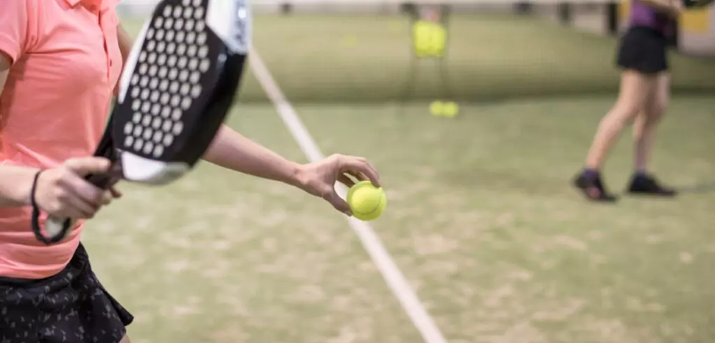 Padel player about to serve the ball