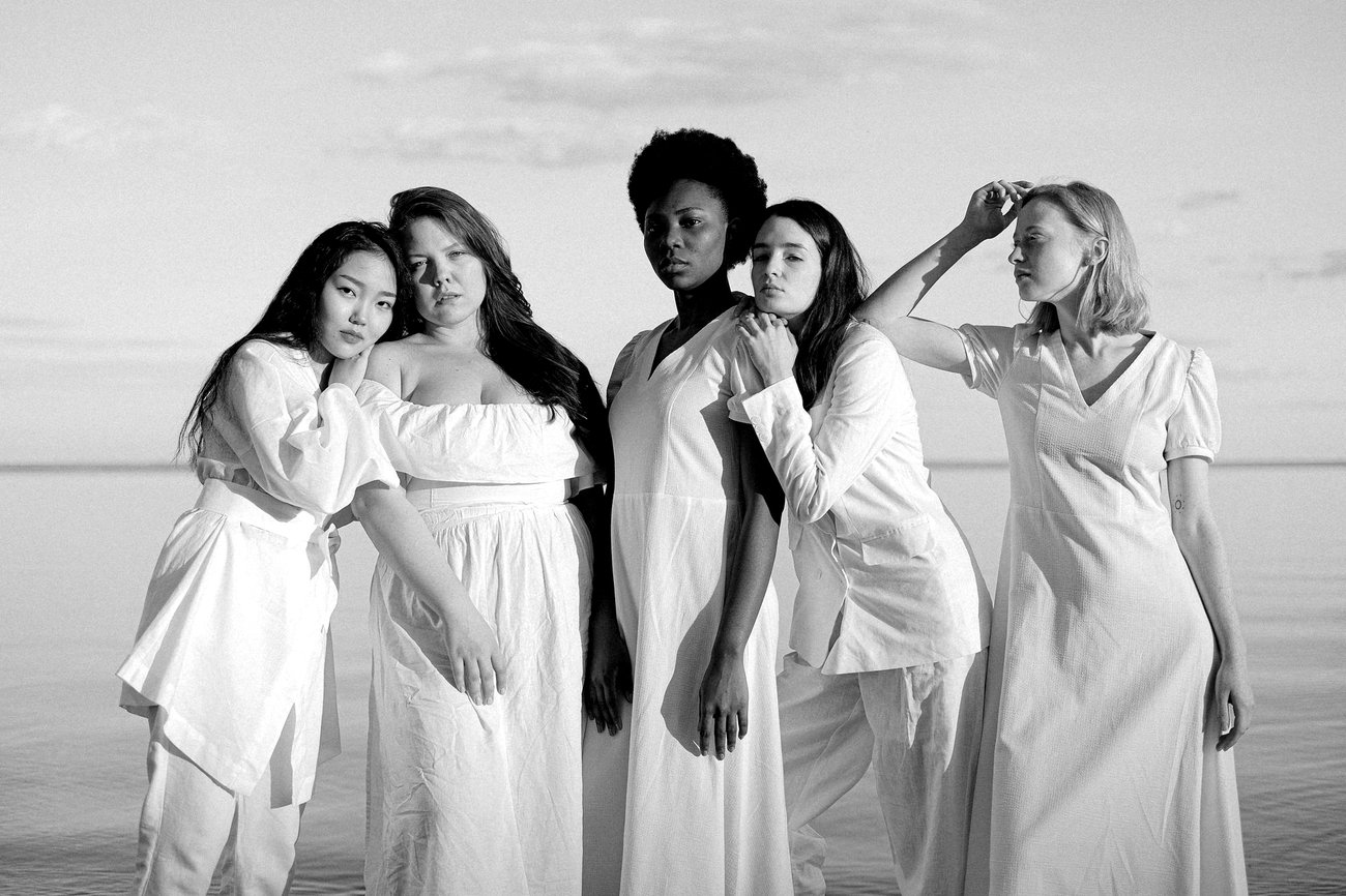 Women standing together by the water, photographed in black and white