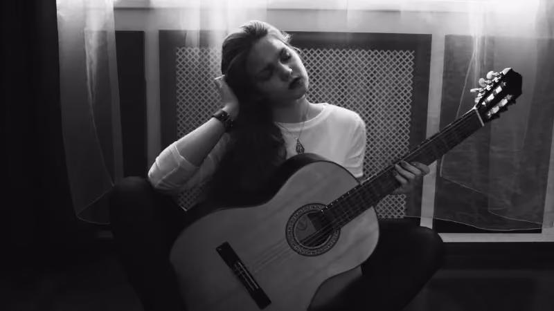 Frau lächelt und hält eine Gitarre