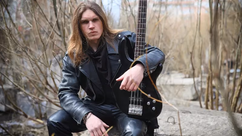 Man sitzt mit einer Gitarre in der Natur