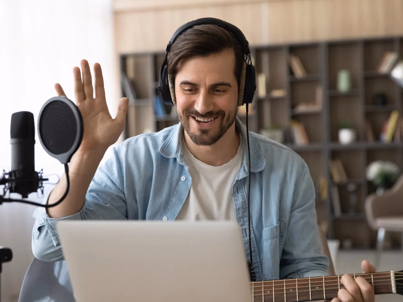 Musiklehrer schaut in den Laptop und begrüßt den Schüler