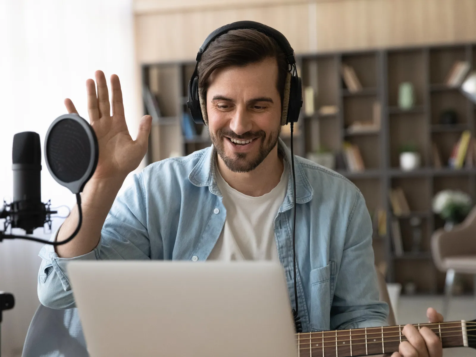 Musiklehrer schaut in den Laptop und begrüßt den Schüler