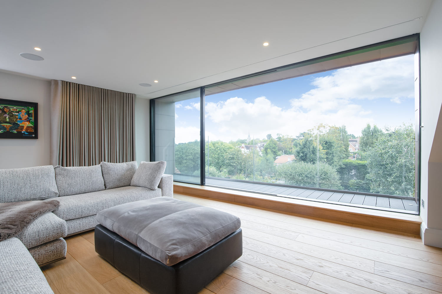 Modern living room without curtains on large windows by Grants Blinds.