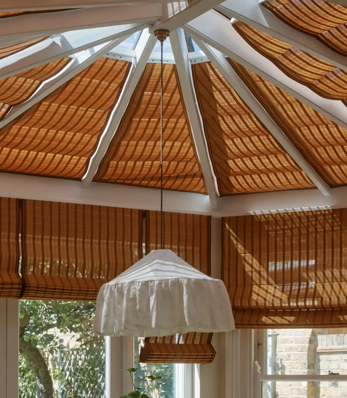 Motorised bamboo roof blinds fitted to the glazed conservatory roof of a London garden room