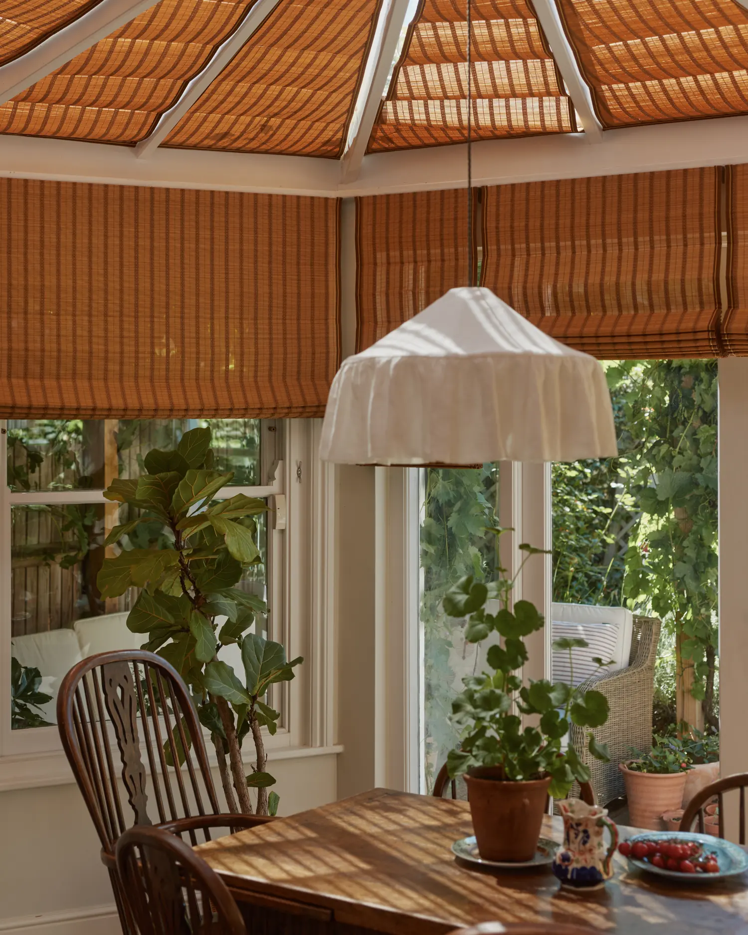 Bamboo Roman blinds at the garden room windows beside the dining table