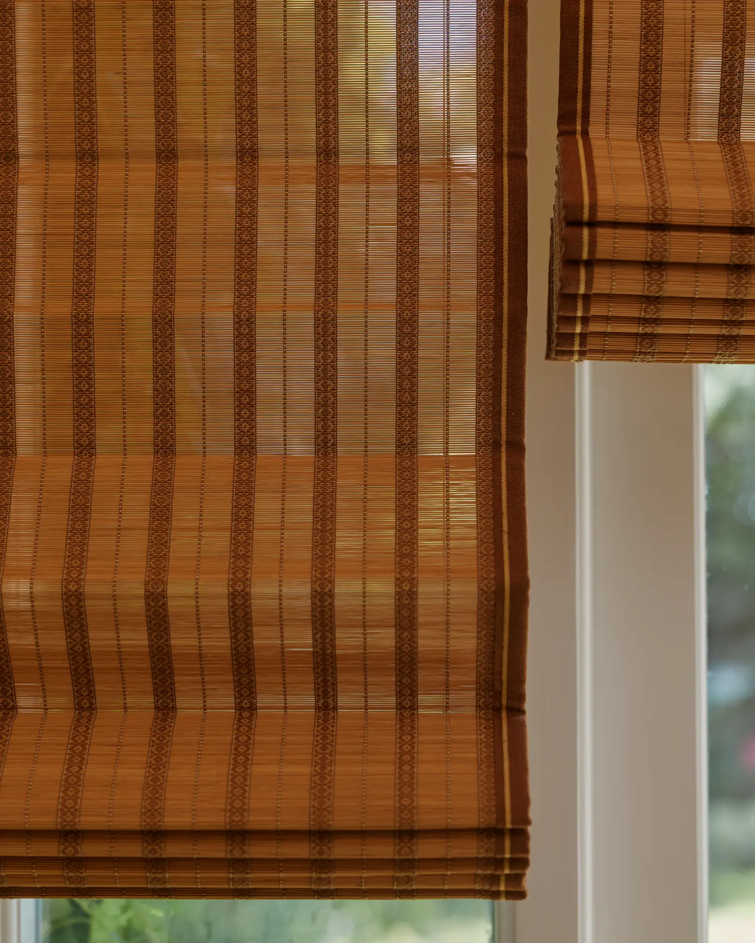 Two IV Hokkaido bamboo Roman blinds stacked in their folds at the window head
