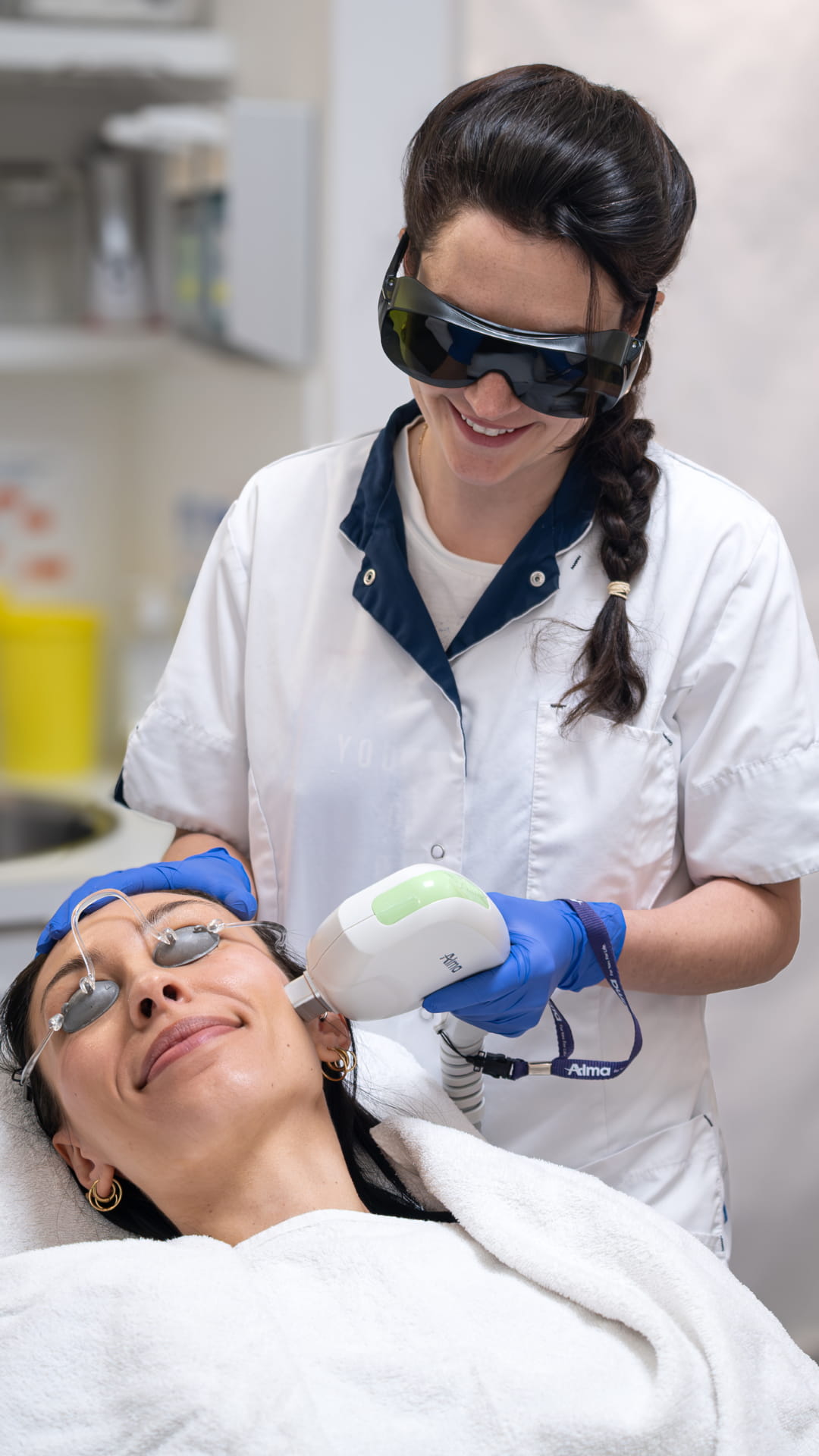 Behandelaar voert IPL-laserbehandeling uit bij patiënt in de behandelstoel.