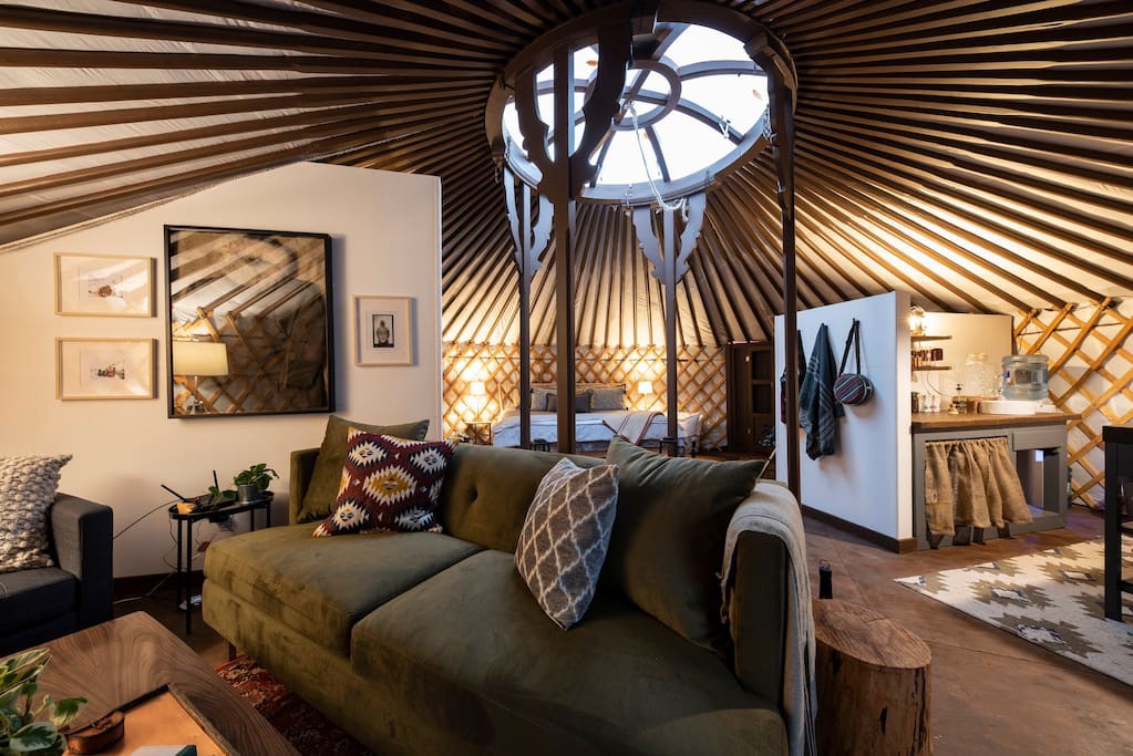 A dark grey yurt with a comfy green couch