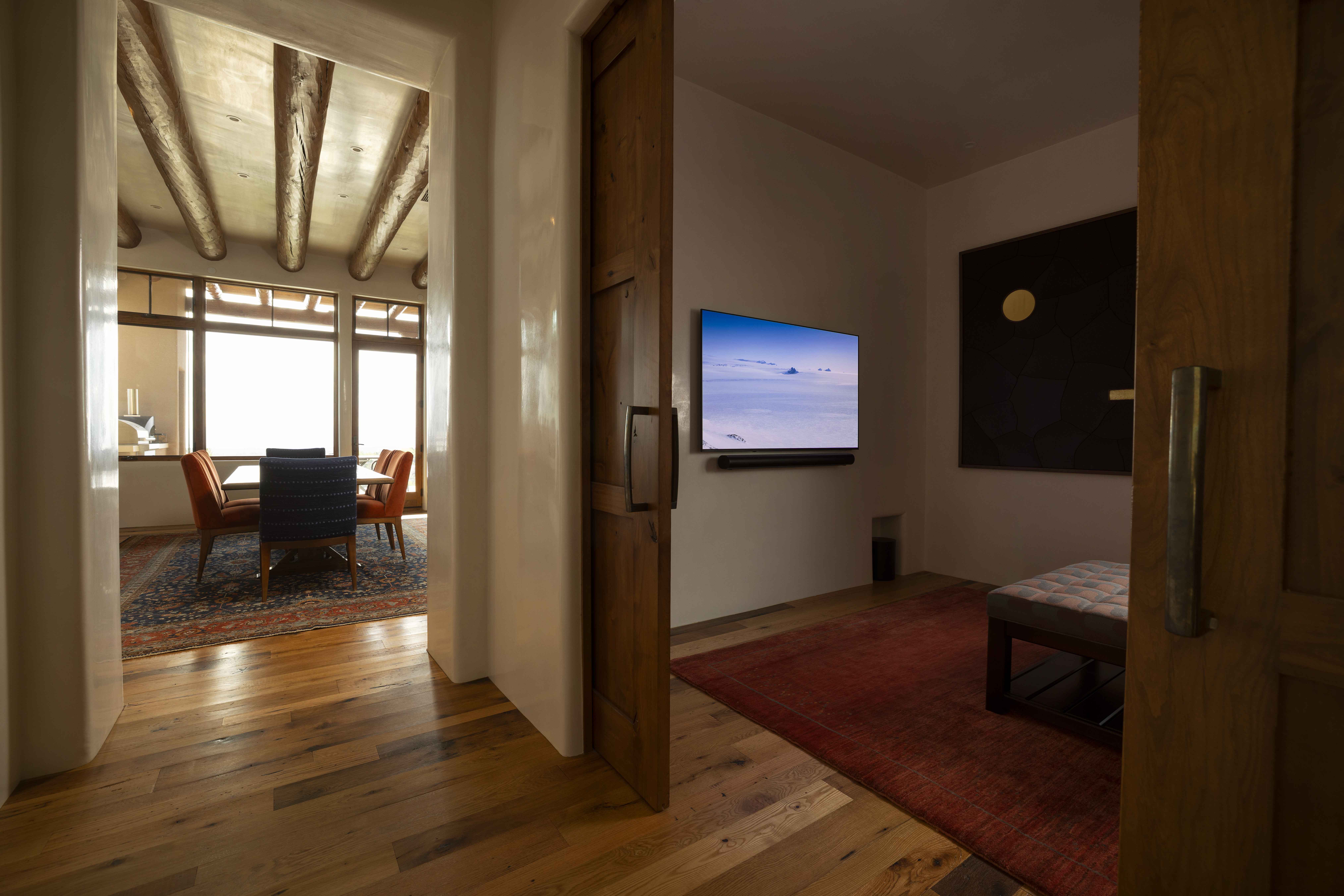 Living room with wall-mounted TV seen from a carved wood doorway
