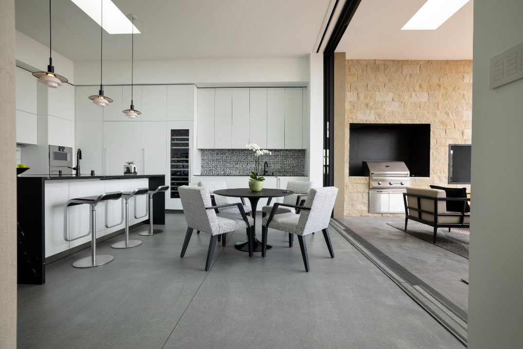 Modern kitchen opening onto an outdoor grill and patio