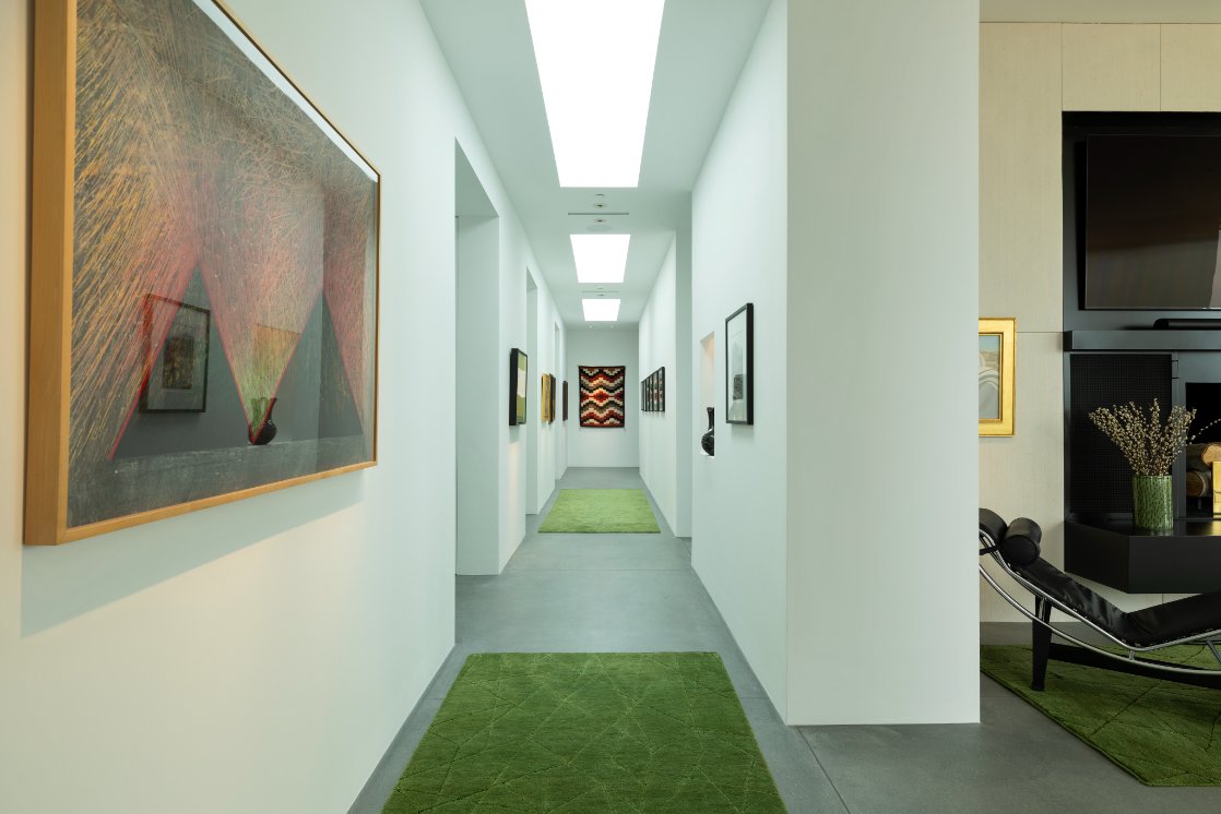 Skylit gallery hallway lined with framed art
