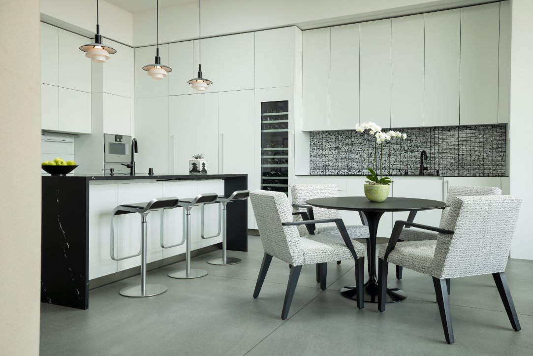 White modern kitchen with breakfast table and pendant lights