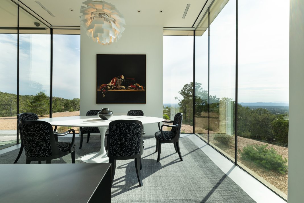 Glass-walled dining room with sculptural pendant and desert views