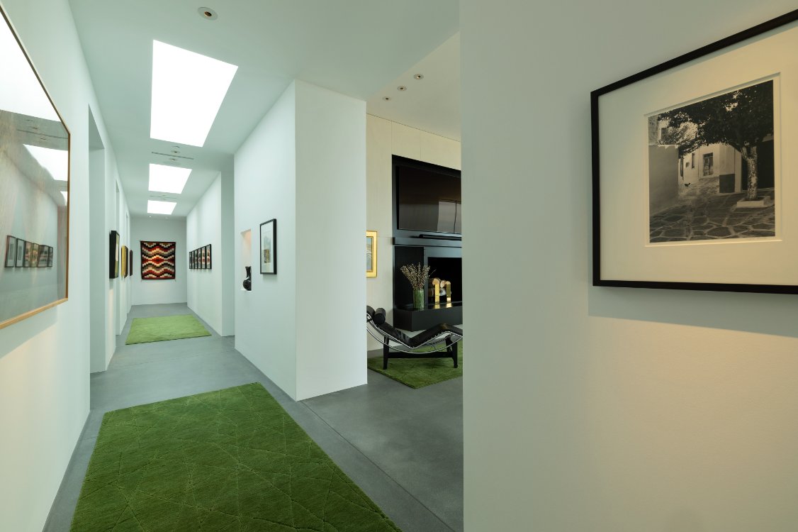 Bright gallery hallway with skylights and framed artwork