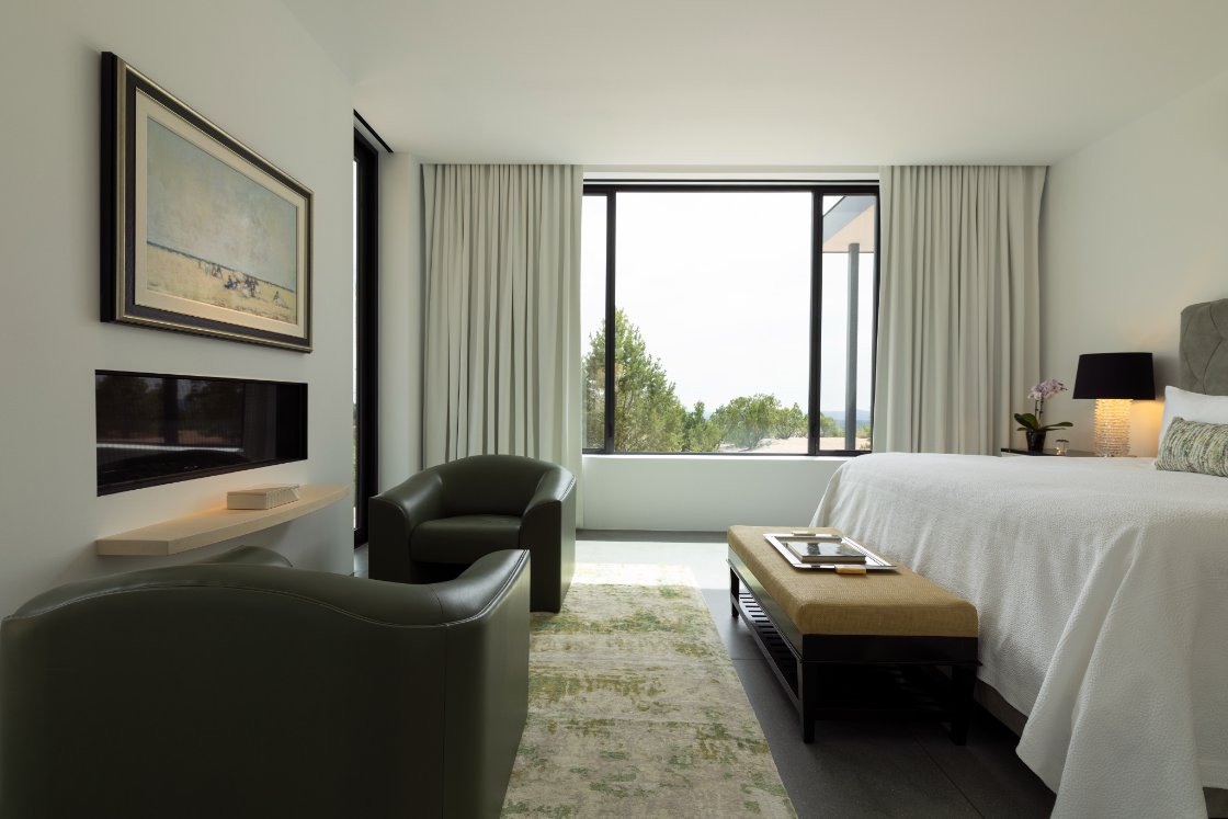 Primary bedroom with sitting area and window views