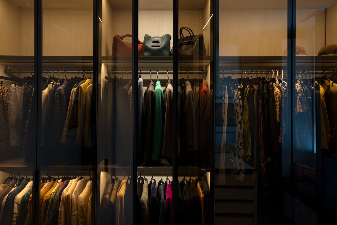 Glass-front closet with warm accent lighting