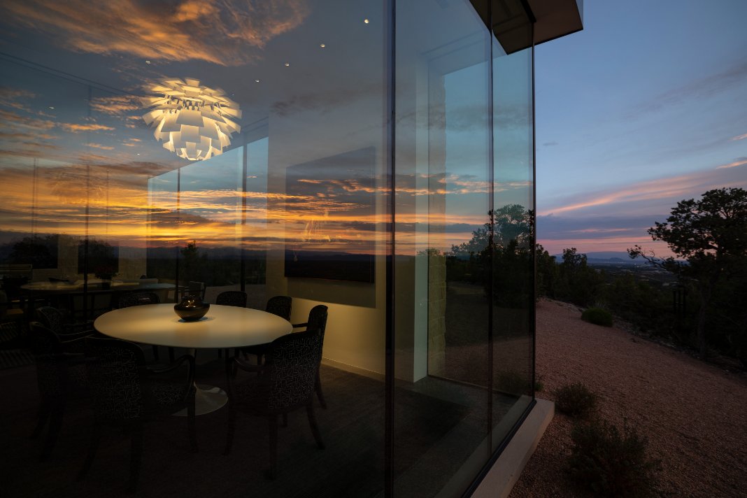 Glass-walled dining room overlooking a Santa Fe sunset