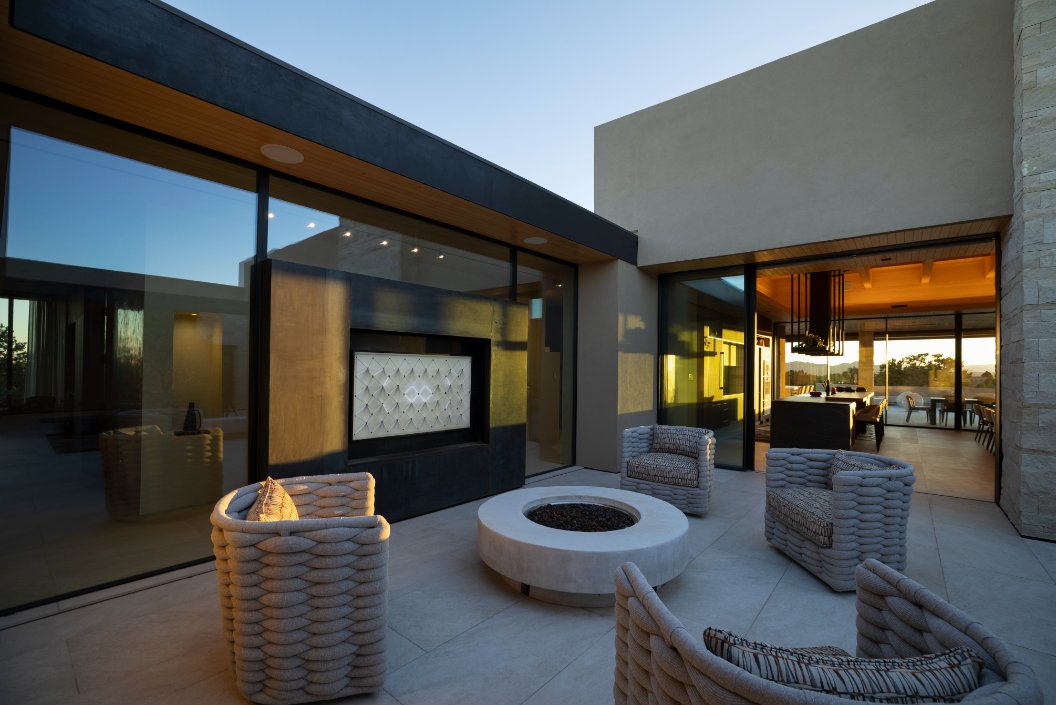 Outdoor living courtyard with fire pit, lounge chairs and outdoor TV