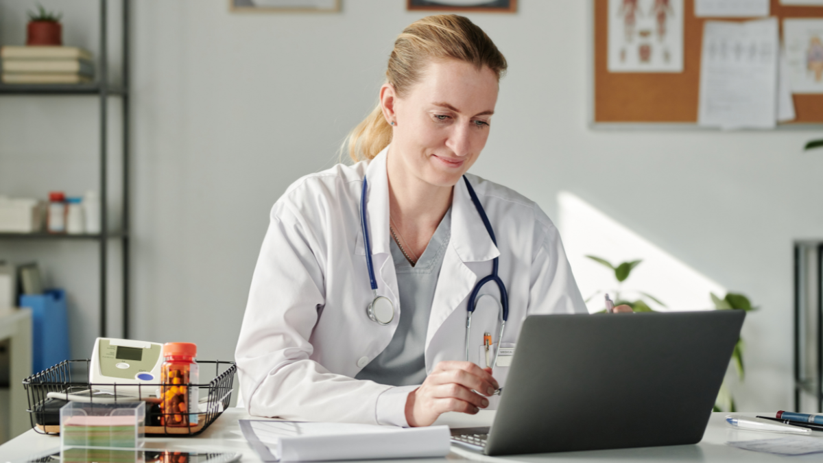 An orthopedic surgeon looking at her computer, ready to get medical malpractice insurance quotes with DrsCoverage.