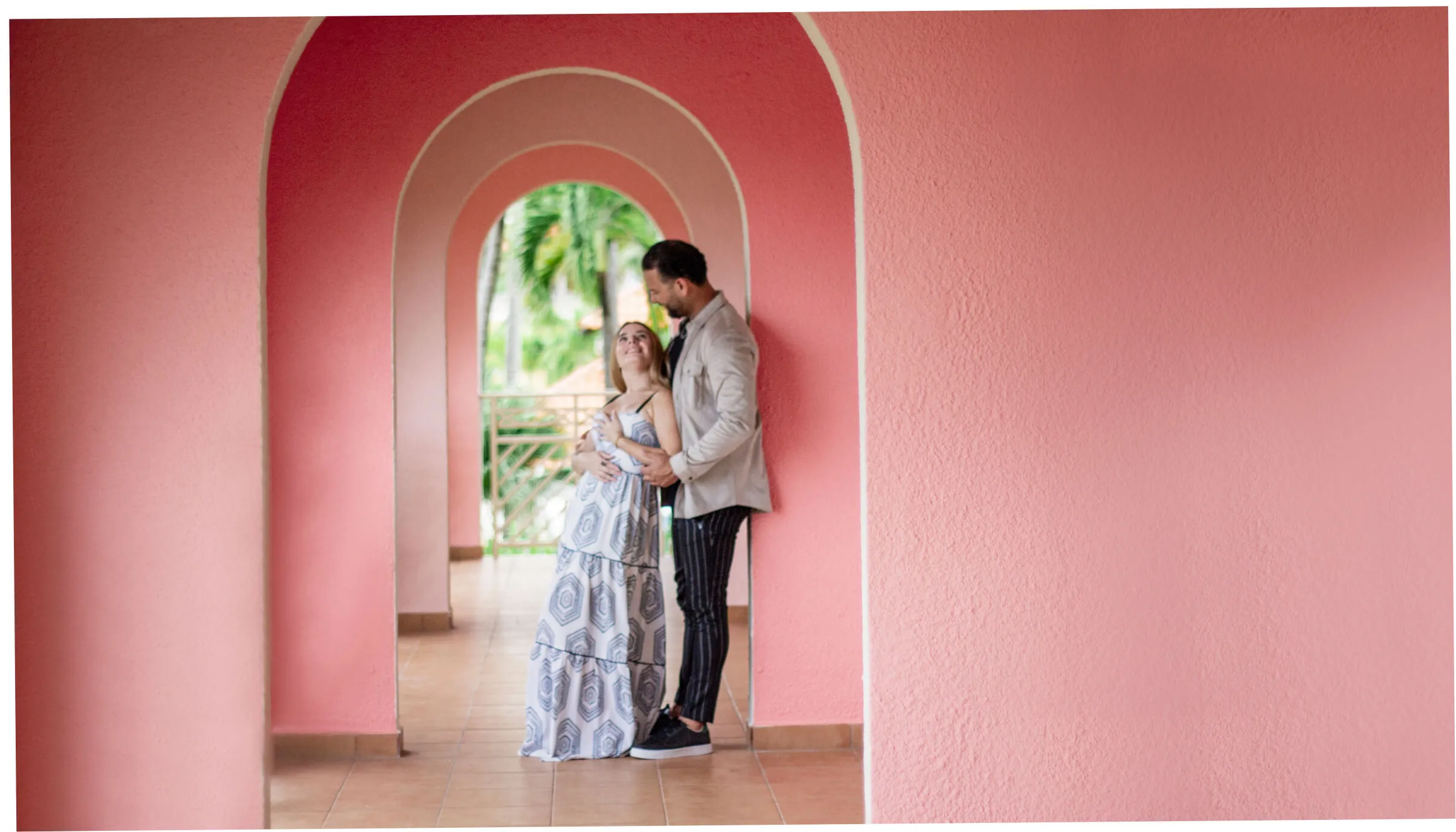 Couple standing in a pink archway on the Palmas property