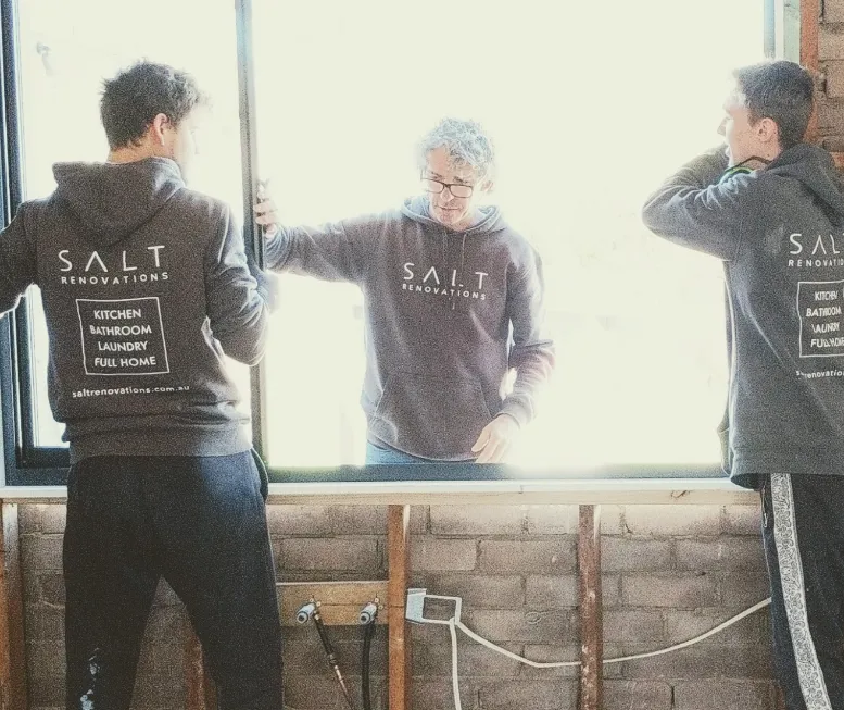 Three carpenters working together on a home renovation.