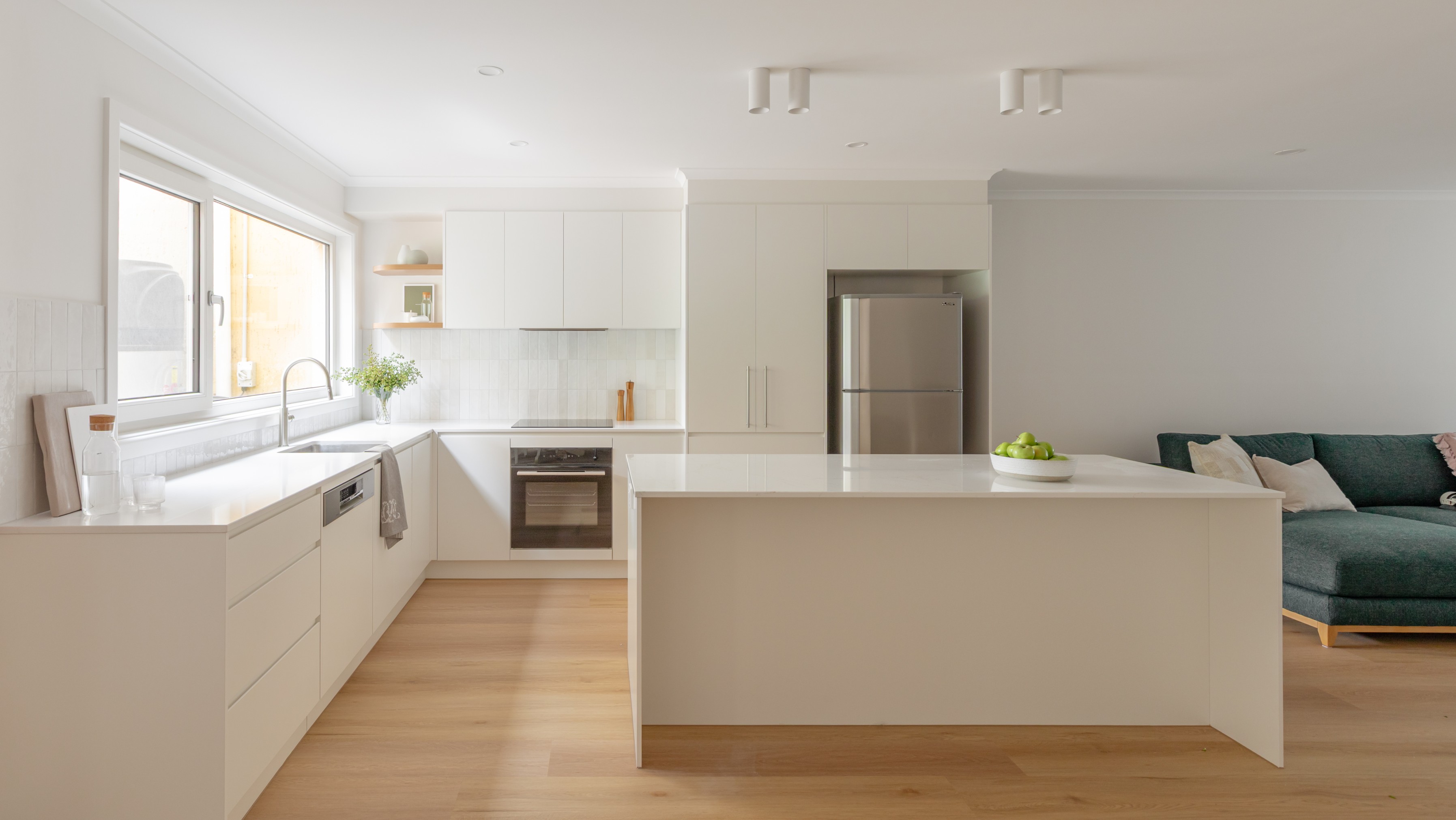Open plan custom kitchen with grey cabintery and timber details