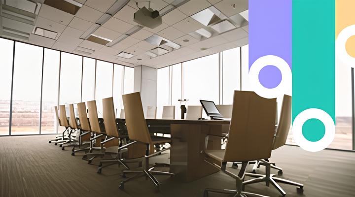 Modern conference room with a long wooden table surrounded by brown leather office chairs on wheels, floor-to-ceiling windows with blinds partially closed, and overhead recessed lighting.