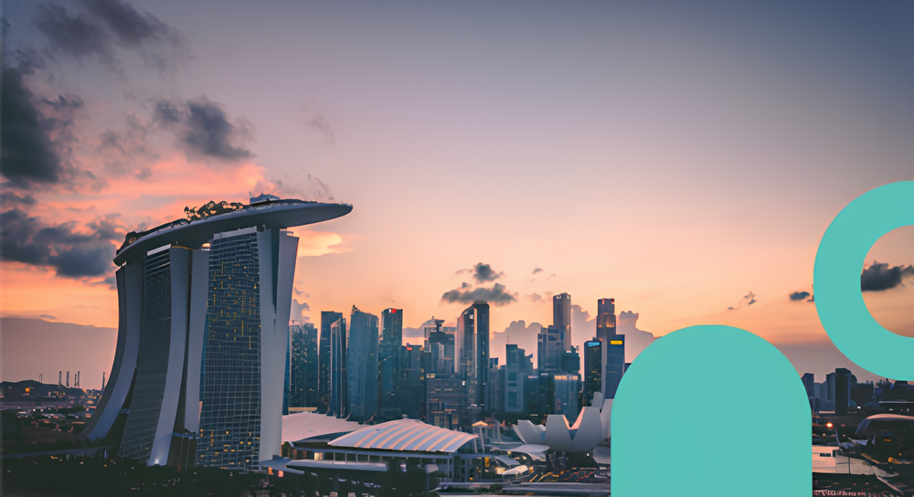 Singapore skyline at sunset featuring the iconic Marina Bay Sands hotel with its three towers and rooftop SkyPark, with other tall buildings and a colorful sky with scattered clouds in the background.