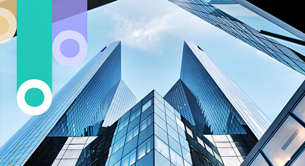 Low-angle view of modern glass skyscrapers against a blue sky with white clouds, framed by colorful semi-transparent vertical shapes on the left.