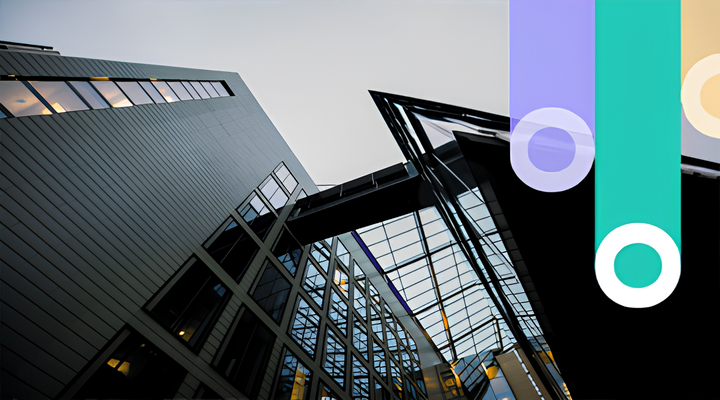 Upward view of a modern office building with glass windows and a geometric glass roof structure against a clear sky.