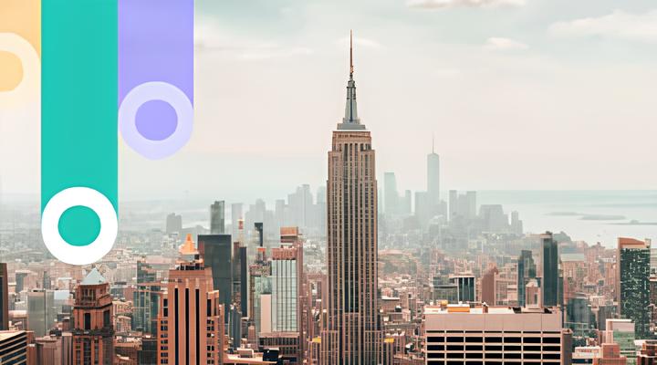 Cityscape featuring the Empire State Building prominently in the center with surrounding skyscrapers and a hazy skyline in the background.