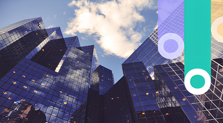 Upward view of modern glass skyscrapers reflecting the blue sky and white clouds.
