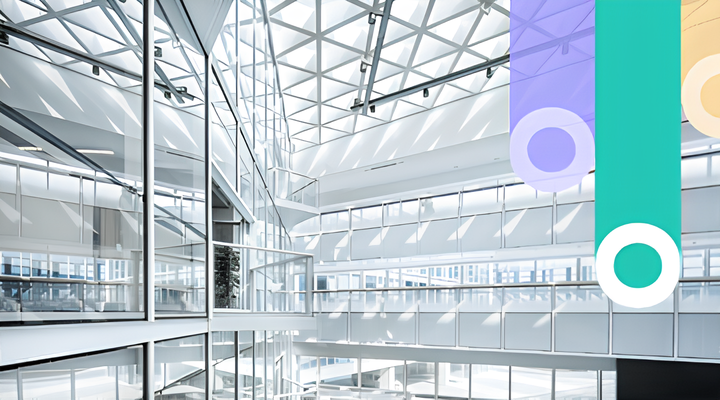Interior of a modern building with large glass windows and a geometric ceiling structure allowing natural light inside, featuring a white and airy design.