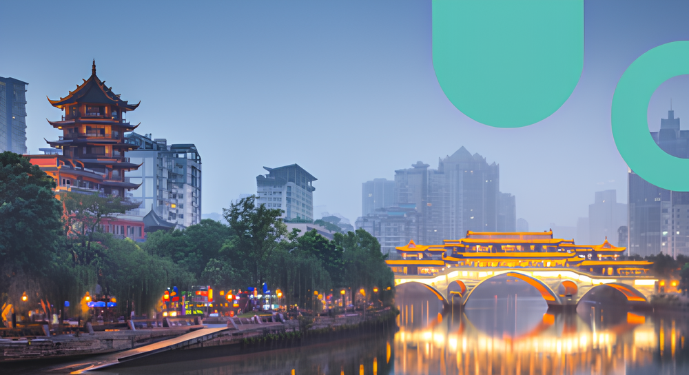 Cityscape at dusk featuring a traditional Asian-style pagoda on the left and an illuminated arched bridge spanning a calm river, with modern buildings in the background.