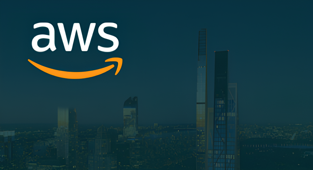 AWS logo with white letters and an orange smile arrow above a nighttime cityscape featuring tall illuminated skyscrapers against a dark blue sky.
