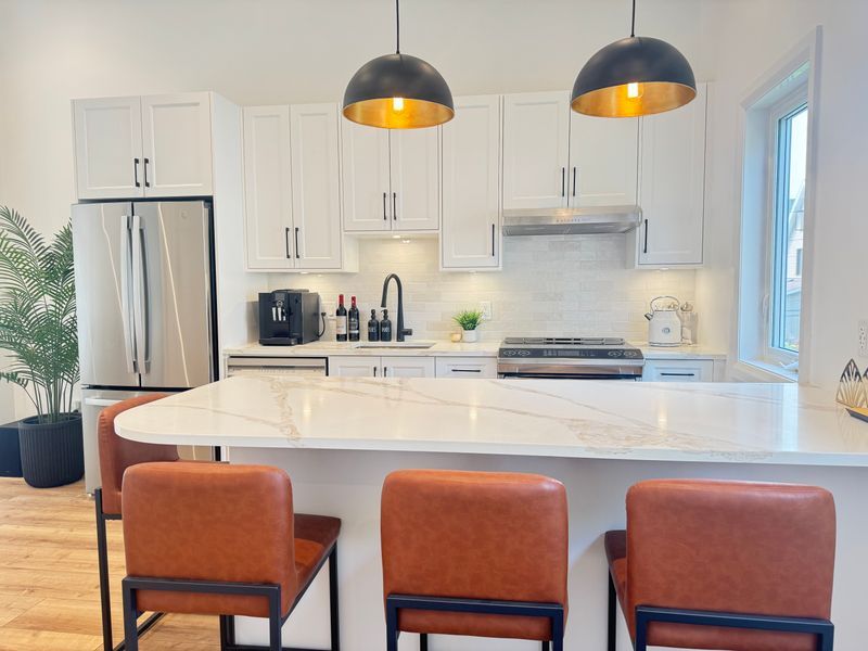 Full kitchen remodel with a quartz island and white cabinets in Ottawa