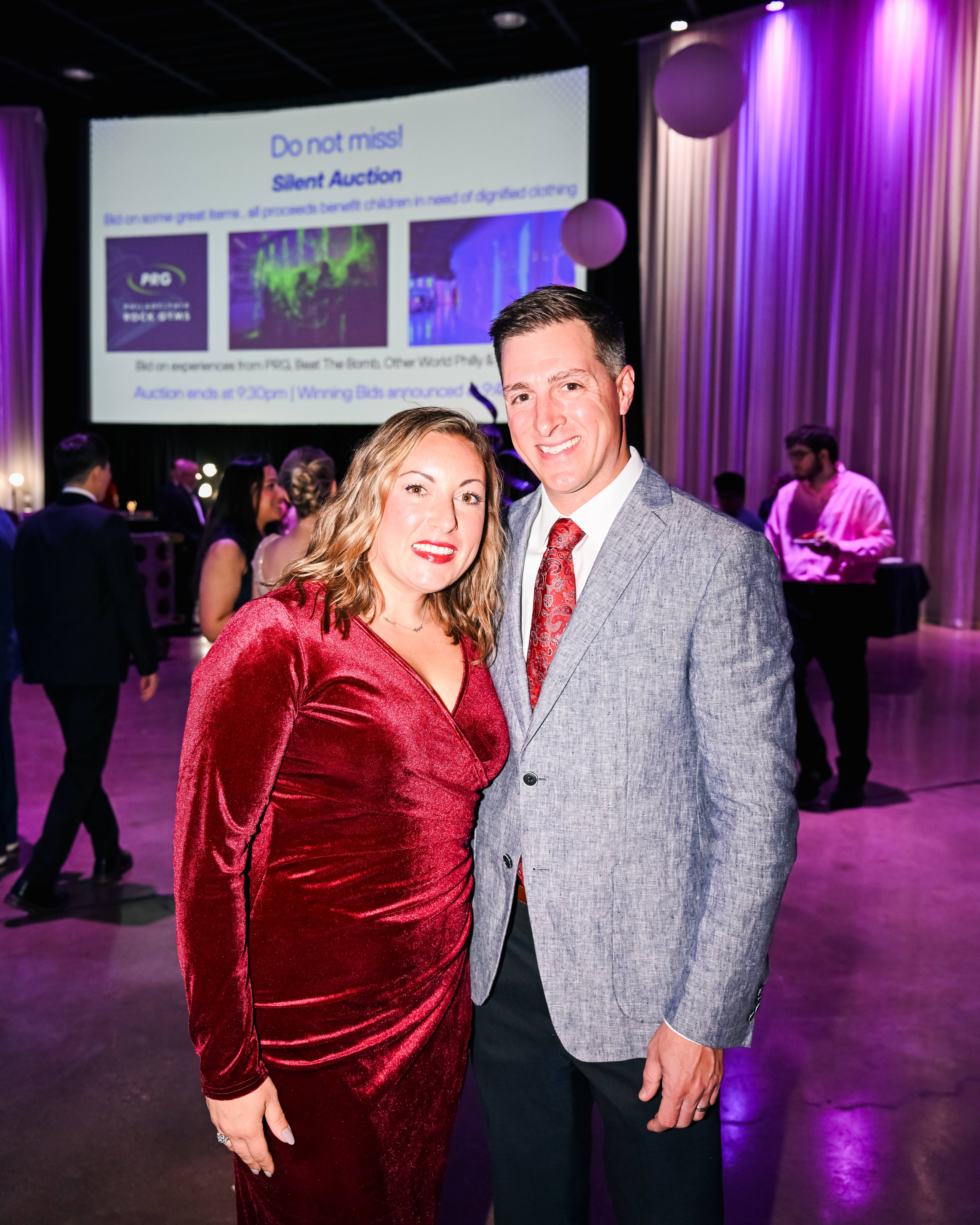 Two guests in front of the silent auction screen