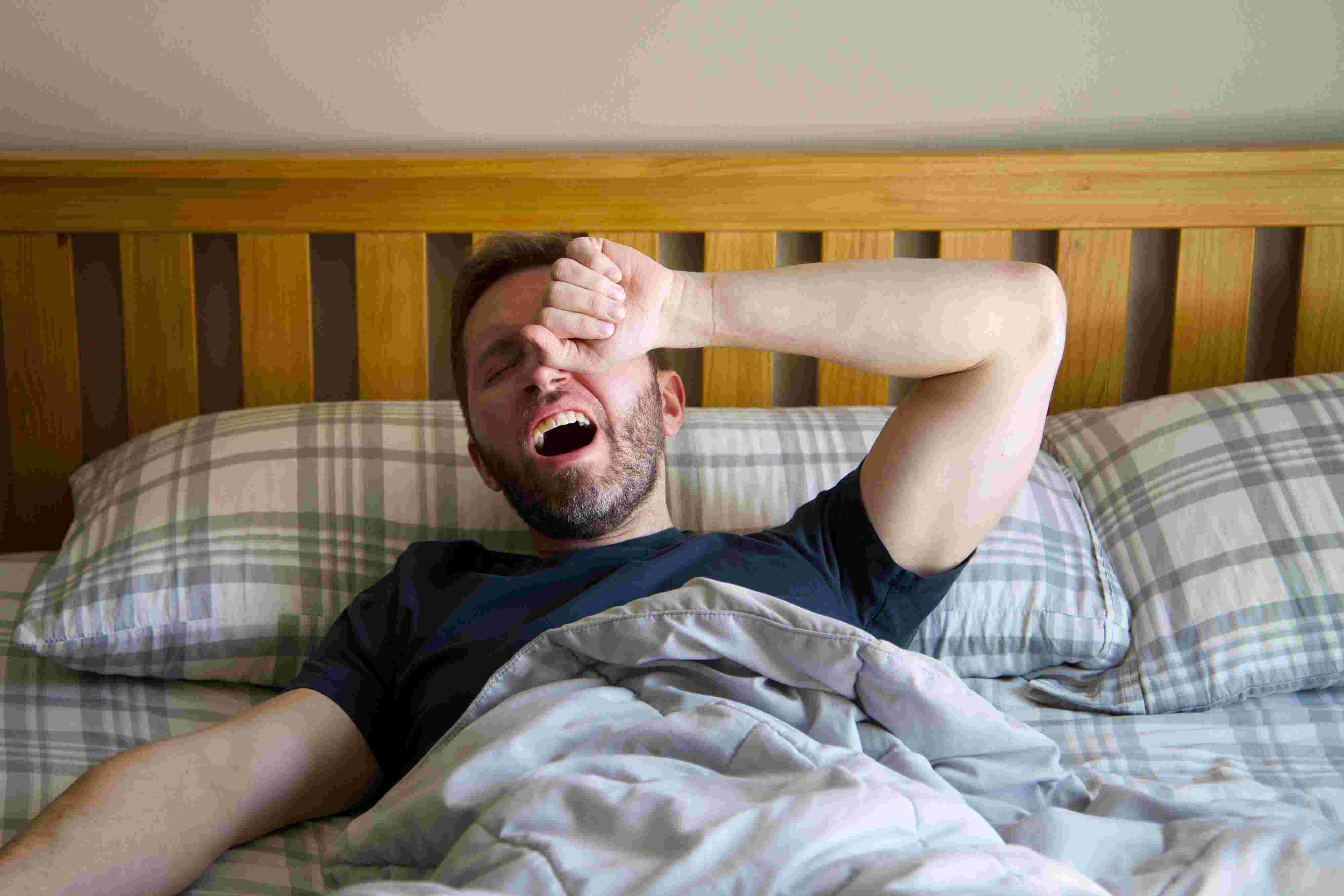 Man yawning and waking up in bed. Photo by Andrew Patrick Photo from Pexels.