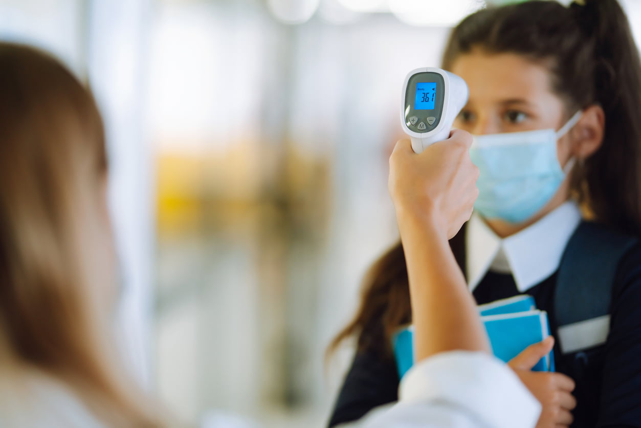 Schulkrankenpflegerin misst Fieber bei Schulkind