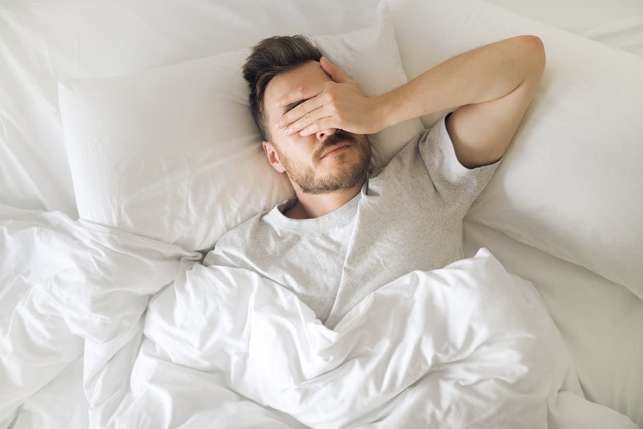 Erschöpfter Mann im Bett