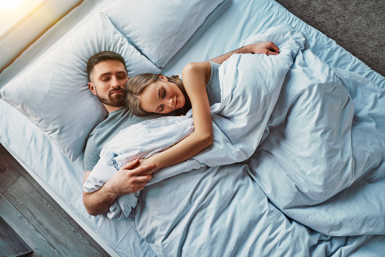 Junges Paar liegt im Bett