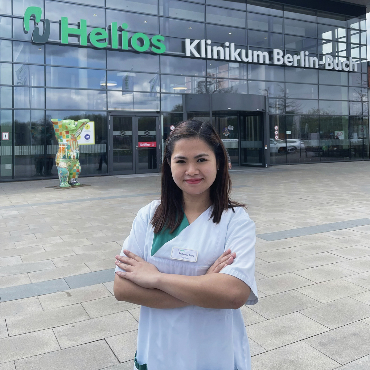 Pflegefachkraft Romamea vor dem Helios Klinikum Berlin-Buch
