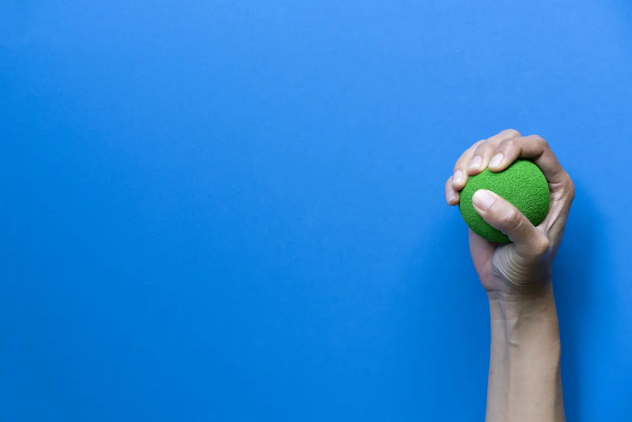 Frau Hand hält Stressball auf blauem Tisch Hintergrund