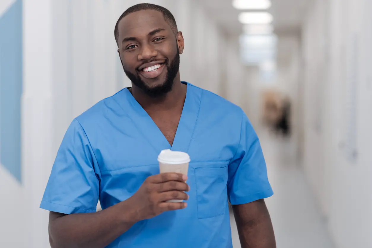 Pfleger mit einem Kaffee in der Hand