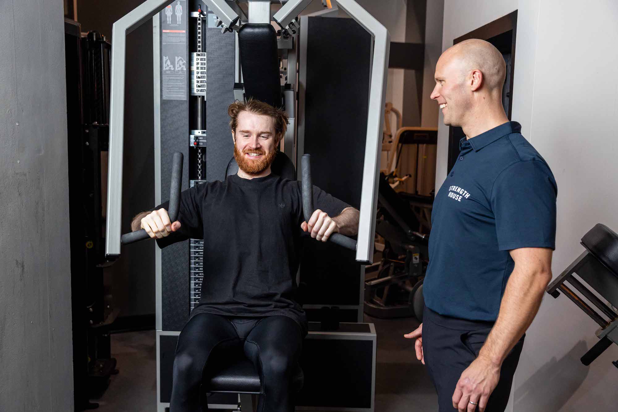 Trainer demonstrating correct exercise technique to client during personal training session in London studio