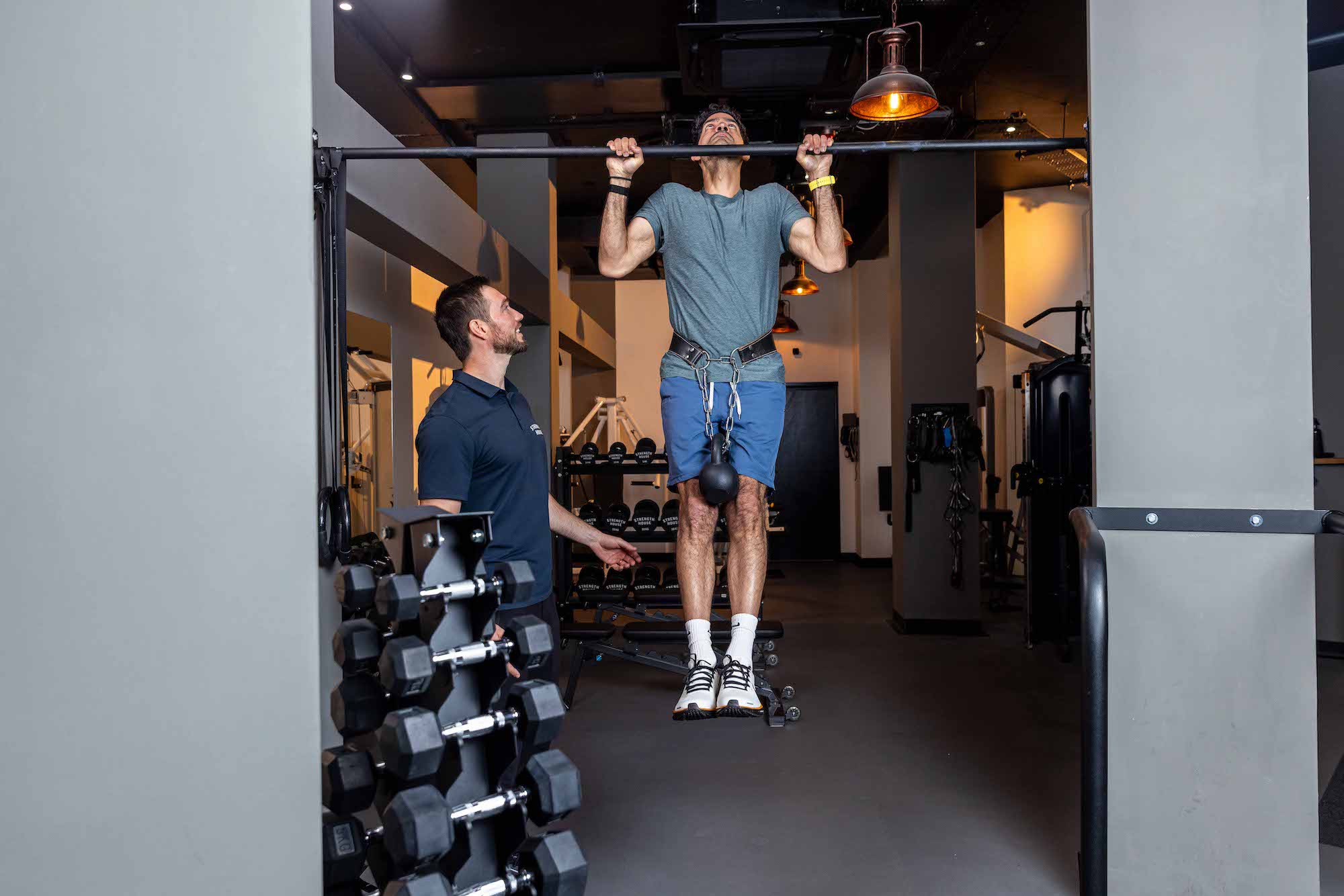 Expert personal trainer assessing client’s movement pattern in initial fitness assessment — Strength House, London