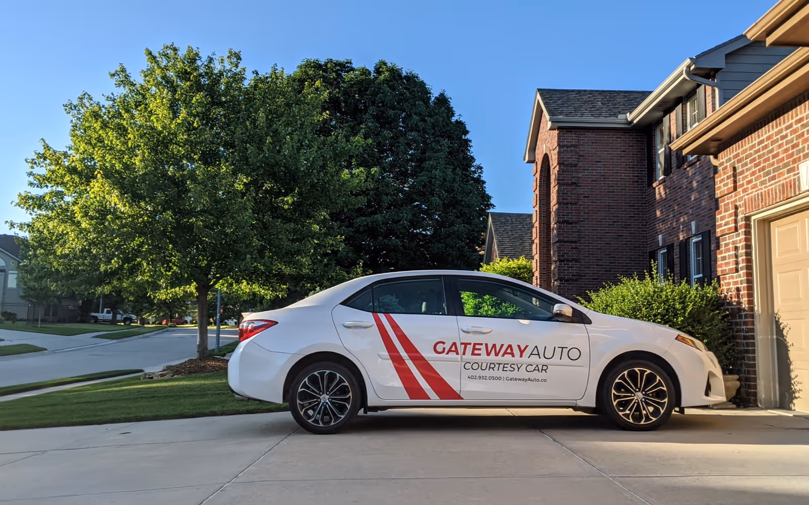 A Gateway Auto courtesy car parked in the driveway of a suburban home